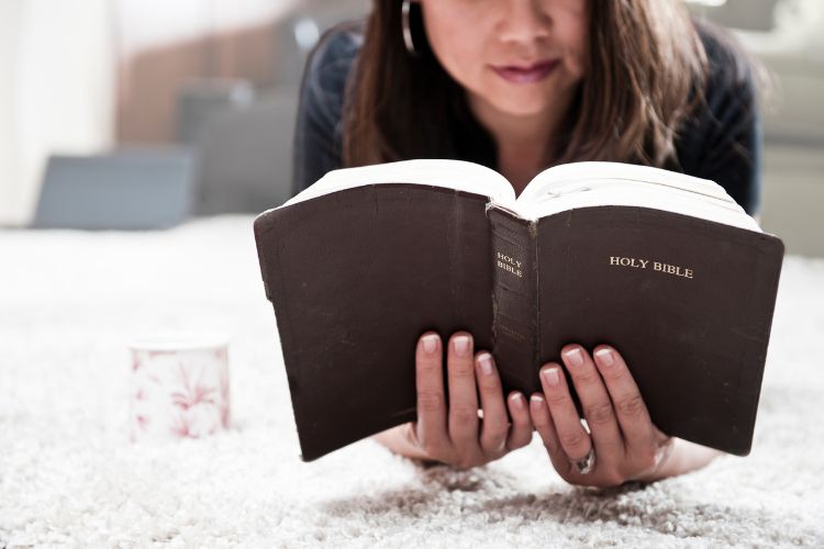 woman reading Bible with tea cup