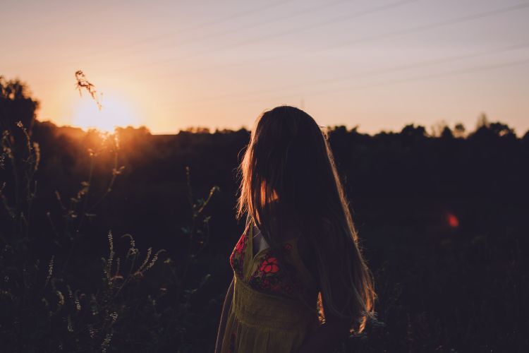 woman looking back at the rising sun
