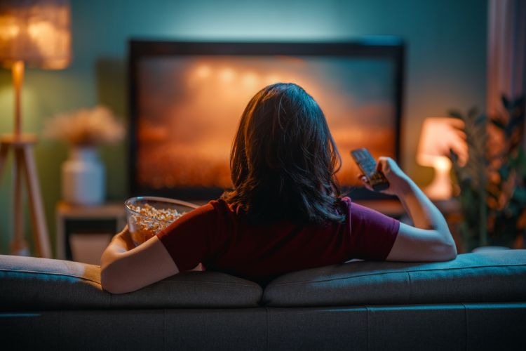 woman with remote and popcorn watching tv