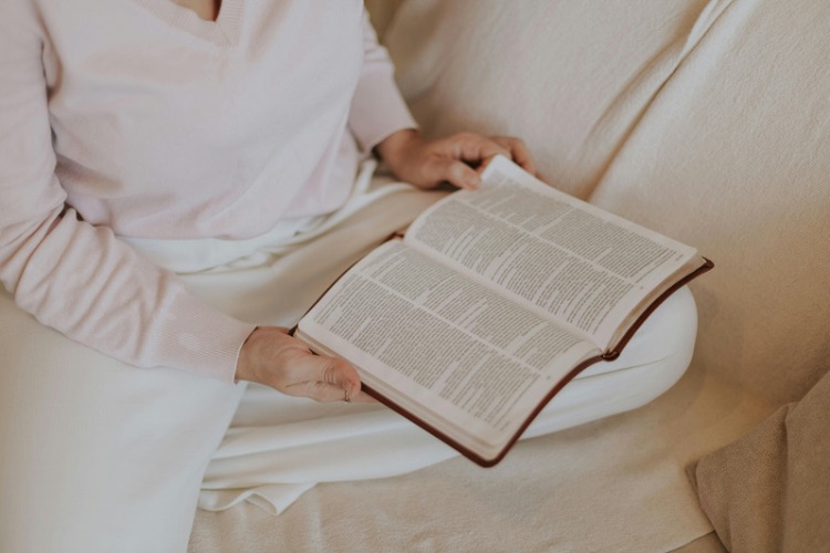 woman relaxing on couch with her Bible